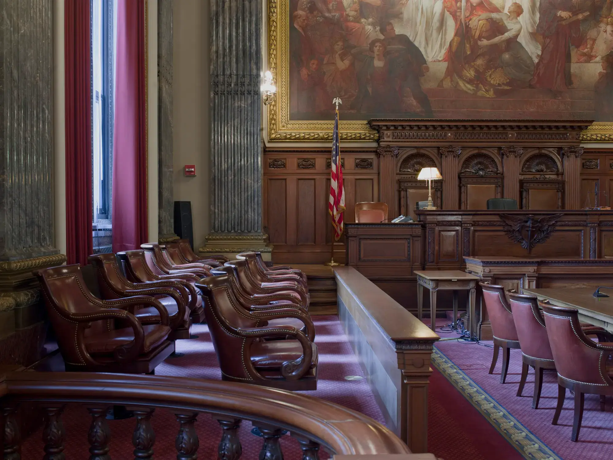 A wood-panelled courtroom with the judge's bench and jury box