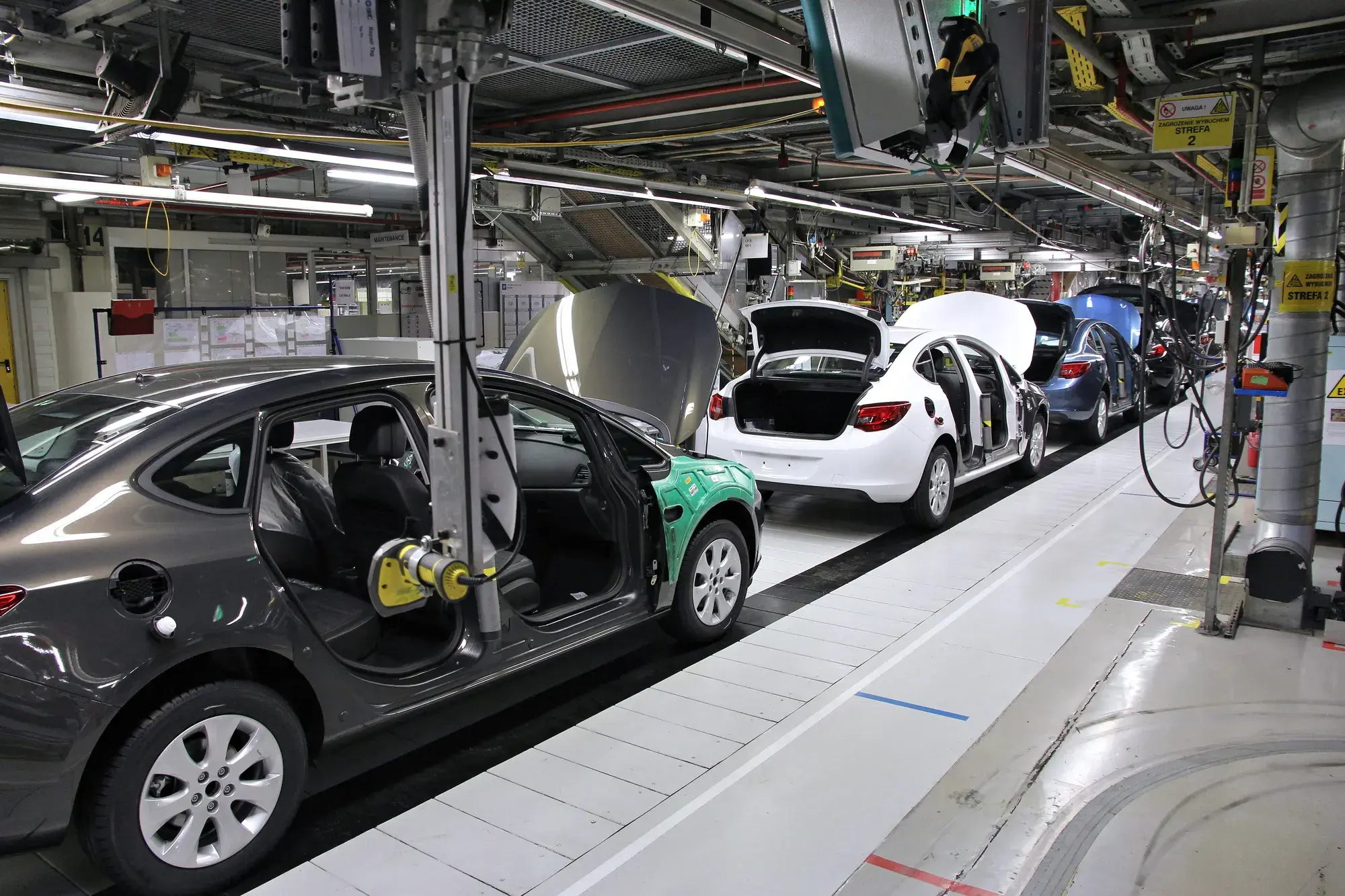 Cars moving along a factory assembly line